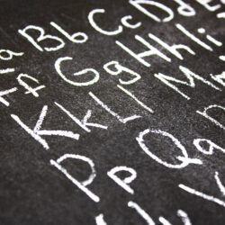 English alphabet, letters inscribed with chalk on a blackboard. English alphabet, learn English, knowledge, education.